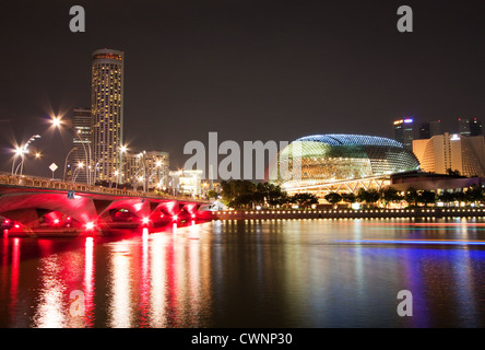 Night photo of Esplanade Theater and Bridge beautifully illuminated at Marina Bay, Singapore. Long exposure with light trails from boats on river Stock Photo