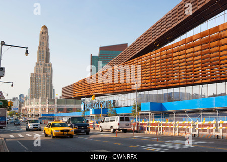 New York City Taxi drives pass the new Barclays Center home of the Brooklyn Nets Sports Arena and Concert Hall.  The landmark Williamsburgh Savings Bank Tower in the background, Brooklyn, NY, USA Stock Photo