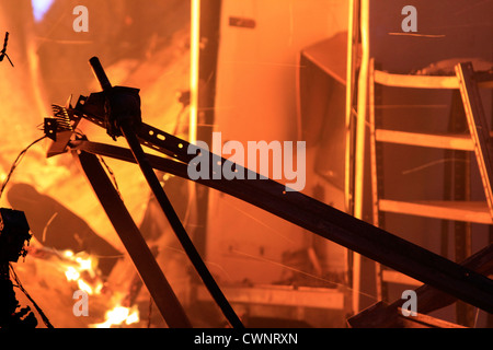 House interior destroyed by intense fire. Flames, smoke and sparks engulfing the interior of a home. Stock Photo