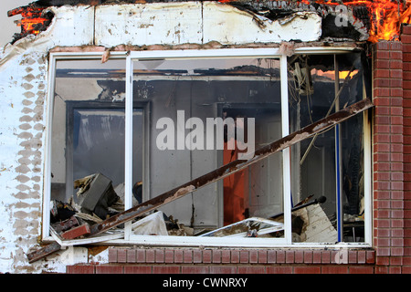 House interior destroyed by intense fire. Flames, smoke and sparks engulfing the interior of a home. Stock Photo