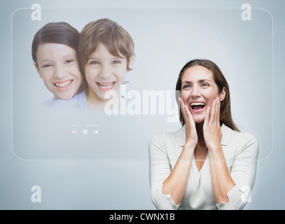 Woman doing video conference with children using advanced touch screen technology Stock Photo