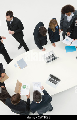 Business associates working together in small groups around table Stock Photo