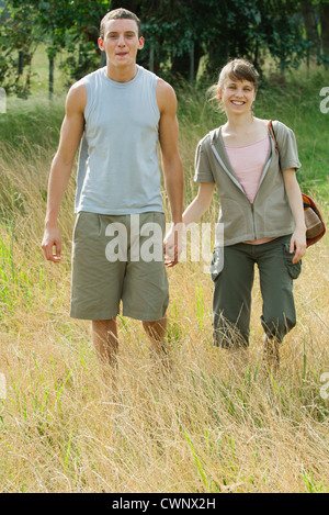 Young couple going for hike, holding hands Stock Photo