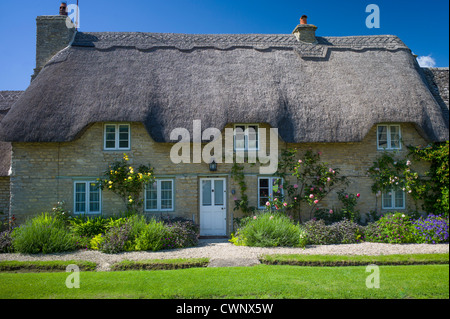 Quaint traditional thatched cottage in Minster Lovell in The Cotswolds, Oxfordshire, UK Stock Photo