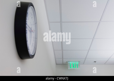 Exit sign and wall clock in office Stock Photo