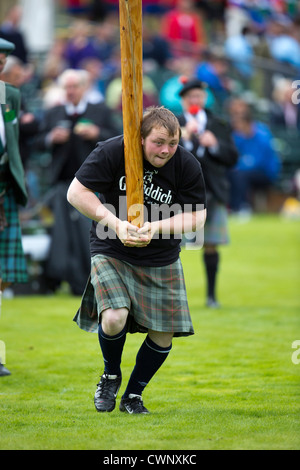 Heavies compete in traditional highland sporting events such as throwing a stone for distance and Tossing the Caber at Braemar Stock Photo