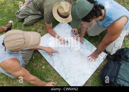 Hikers using compass and looking at map together, high angle view Stock Photo