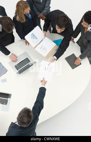 Business associates reviewing documents in meeting Stock Photo