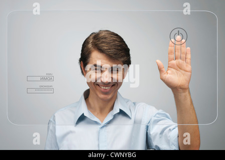 Man touching power button on advanced touch screen interface Stock Photo