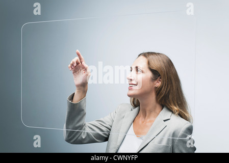Businesswoman using large transparent touch screen Stock Photo
