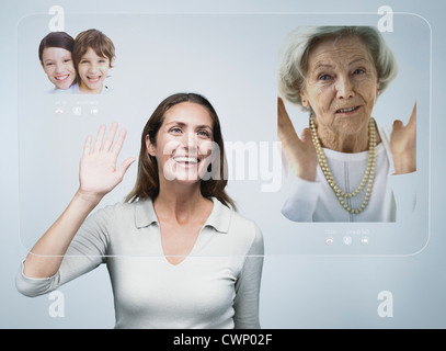 Woman doing video conference with family using advanced screen technology Stock Photo