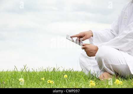 Man holding tablet pc on meadow Stock Photo