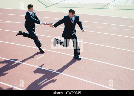 Businessmen running relay race Stock Photo