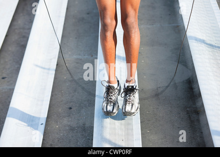 Man jumping rope on bleacher, low section Stock Photo