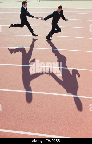 Businessmen running relay race Stock Photo