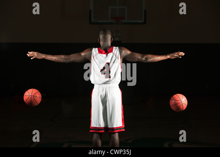 Basketball player dribbling two balls Stock Photo