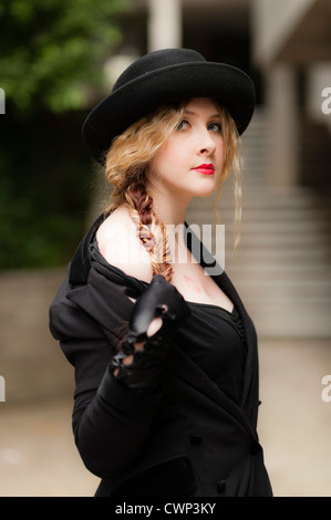 a young attractive woman with blonde hair and red lips wearing black in an Alt alternative fashion shoot, on location UK Stock Photo