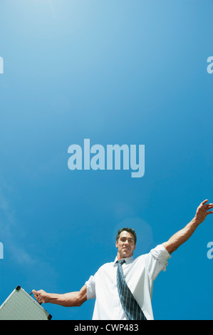 Mid-adult businessman carrying briefcase, low angle view Stock Photo