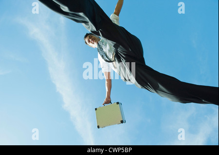 Businessman jumping in air carrying briefcase, directly below Stock Photo