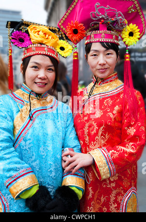 UK. England. London. Two Chinese women in traditional costume during Chinese New Year celebrations. Stock Photo