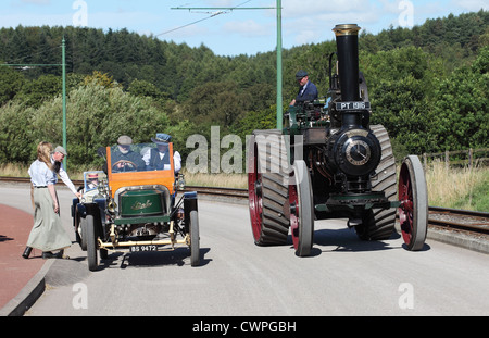 Young woman in period costume boards a Stanley steam car and steam traction engine Beamish Museum, north east England, UK Stock Photo