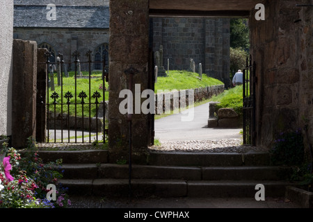 St. Michael the Archangel church in Chagford, Devon, with an elderly male walking alone through the graveyard Stock Photo
