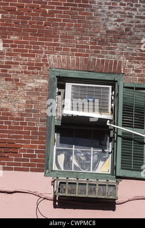 Old sash window mounted air conditioning unit. This is an evaporative cooler also called a swamp cooler, desert cooler Stock Photo