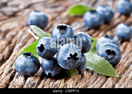 Blueberries with leaves on a old wooden table. Stock Photo