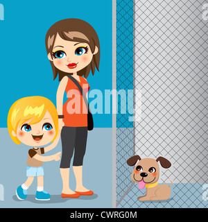 Little boy with mother adopting a cute dog from animal shelter Stock Photo