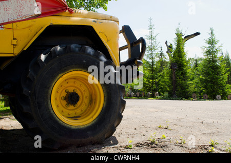 Huge old freight car wheel closeup in park. Agricultural machinery. Stock Photo