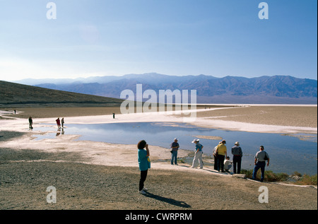 Death Valley National Park, California, USA - Tourists walking on Salt Flats at Badwater Basin, Panamint Mountains beyond Stock Photo