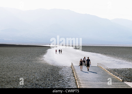 Death Valley National Park, California, USA - Tourists walking on Salt Flats at Badwater Basin, Panamint Mountains beyond Stock Photo