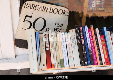 Sign for old bargain paperback books on sale on a bookshelf selling for 50p per book outside a bookshop in England UK Britain Stock Photo