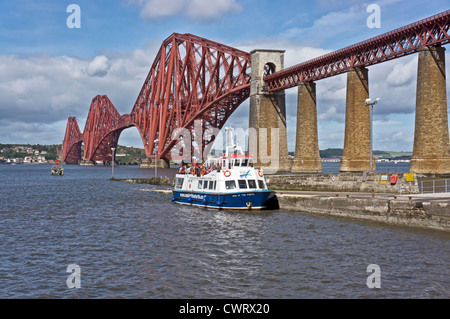 The iconic Forth Rail bridge viewed from the South Queensferry promenade with Maid of the Forth with passengers for Inchcolm Stock Photo