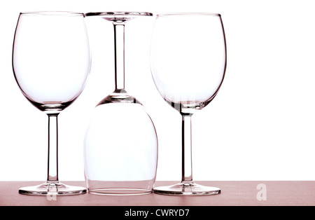 Three empty wine glasses back lit against white background - abstract. Stock Photo