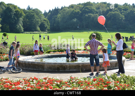 Children playing by fountain in Sunken Gardens, Priory Park, Reigate, Surrey, England, United Kingdom Stock Photo