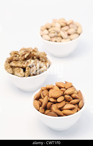 Bowl of Pistachios, almonds and wallnutes on white background Stock Photo