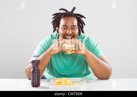 happy fat african american man eating a hamburger Stock Photo