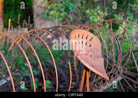 A rusty antique hay rake in the evening sun. Stock Photo