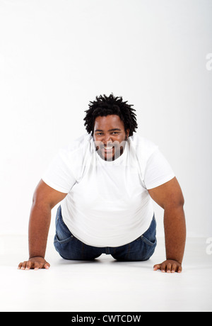 funny fat african man lying on floor Stock Photo