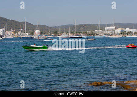 Town of San Antonio, Ibiza, Spain with speedboat towing inflatable with people Stock Photo