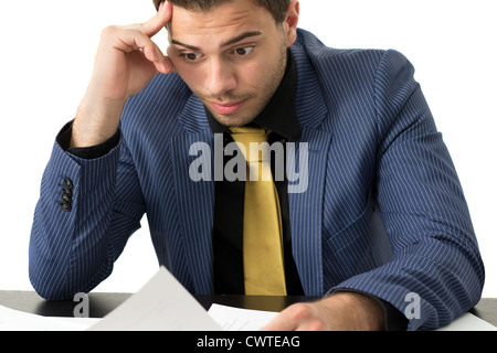 Young stressed overwhelmed businessman wearing a suit and golden tie Stock Photo