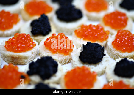 Red and black caviar on slices of bread Stock Photo