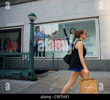 Shoppers pass a window display at a Gap clothing store in the Chelsea neighborhood of New York Stock Photo