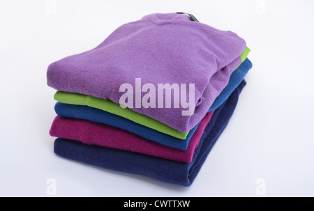 Pile or stack of colorful, folded cashmere or merino wool jumpers isolated on white Stock Photo