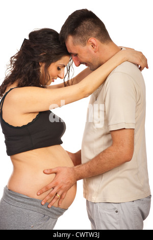 Future father holding and touching his wifes pregnant tummy and feeling baby kicks isolated on white background Stock Photo