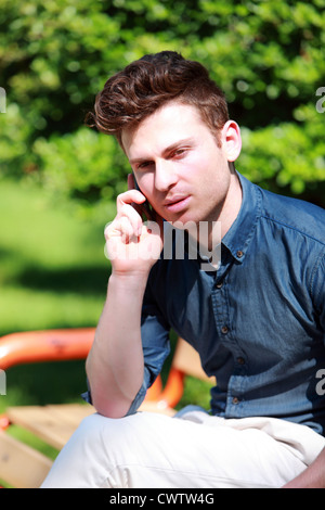Young handsome man in park calling Stock Photo