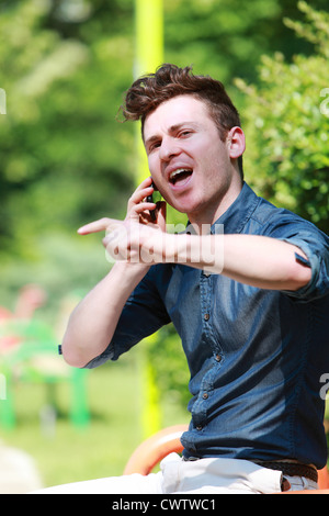 Young red hair man in the park talk on telephone Stock Photo
