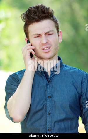 Disappointed young red hair man at telephone Stock Photo