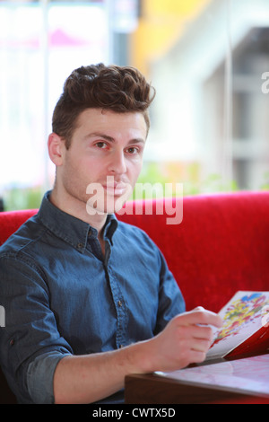 Young handsome man ordering in restaurant Stock Photo